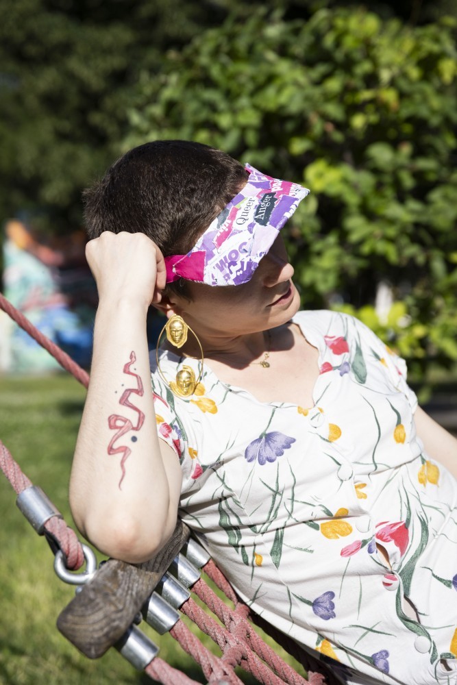 WIENWOCHE 2023: Queer Anger by Sigmund Hutter. A detailed image of Jolanda Helena Resch leaning on the hammock and wearing the sun cap. © WIENWOCHE, Marisel Orellana Bongola