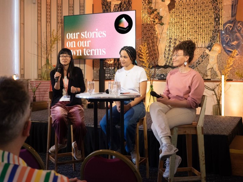 WIENWOCHE 2023: Gewächshaus - our stories on our own terms. Three project members during a public discussion, sitting in front of a Jugendstil mural. © Paola Lesslhumer